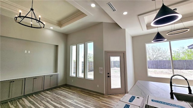 entrance foyer with recessed lighting, a raised ceiling, visible vents, and light wood finished floors