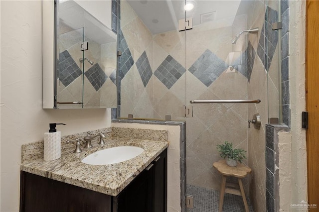 bathroom with vanity and a shower with shower door