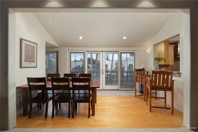 dining room featuring vaulted ceiling and light wood-type flooring