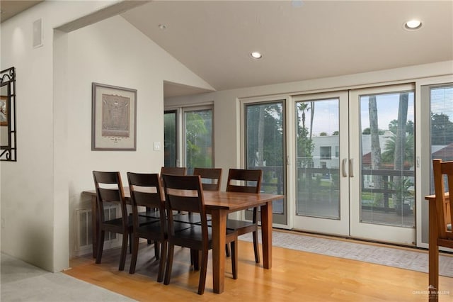 dining room featuring french doors, lofted ceiling, plenty of natural light, and light hardwood / wood-style flooring