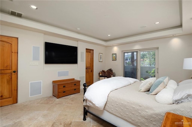 bedroom with access to exterior and a raised ceiling