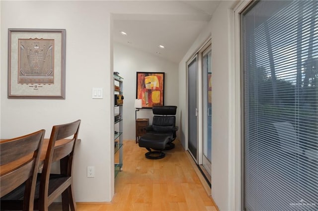 hall with light hardwood / wood-style flooring and vaulted ceiling