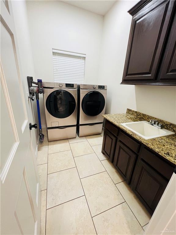 5809 N 3rd St, Mcallen, TX 78504 - laundry area featuring cabinet space, washer and dryer, and light tile patterned floors