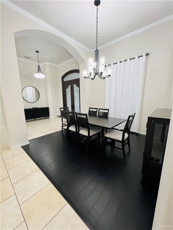 5809 N 3rd St, Mcallen, TX 78504 - tiled dining room featuring arched walkways, french doors, a chandelier, crown molding, and baseboards