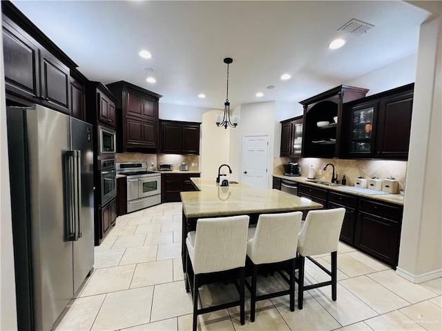 5809 N 3rd St, Mcallen, TX 78504 - kitchen featuring appliances with stainless steel finishes, backsplash, recessed lighting, a kitchen island with sink, and light tile patterned floors