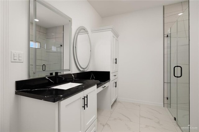 bathroom with vanity, a shower stall, baseboards, and marble finish floor