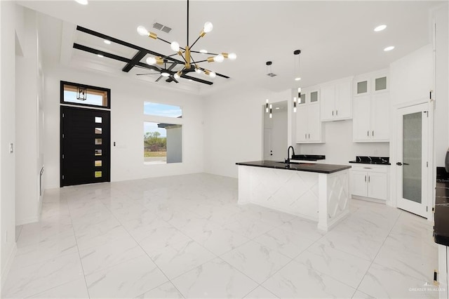 kitchen featuring visible vents, marble finish floor, a sink, dark countertops, and coffered ceiling