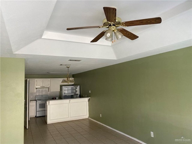 kitchen with range with electric cooktop, a tray ceiling, decorative light fixtures, and white cabinets