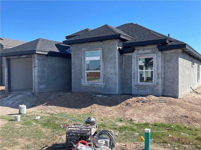 view of side of home with a shingled roof