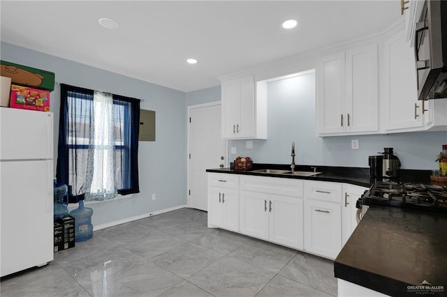 3411 Juan St, Edinburg, TX 78541 - kitchen with freestanding refrigerator, dark countertops, white cabinetry, recessed lighting, and light marble finish flooring