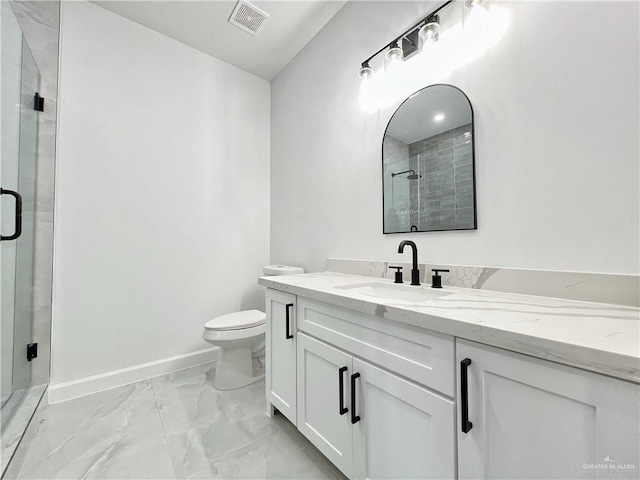 bathroom featuring vanity, toilet, and a shower with shower door