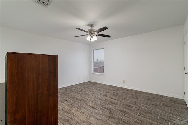 spare room with ceiling fan and dark hardwood / wood-style floors