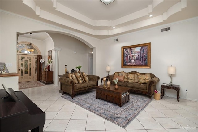 living room with light tile patterned flooring, a raised ceiling, ornamental molding, and ornate columns