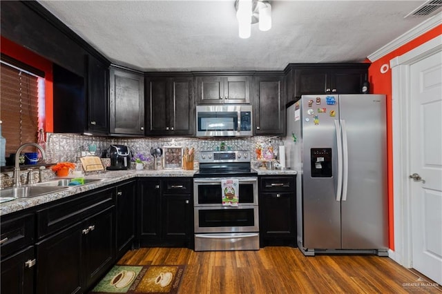1914 W Barcelona Ave, Harlingen, TX 78550 - kitchen with visible vents, dark cabinets, stainless steel appliances, and a sink