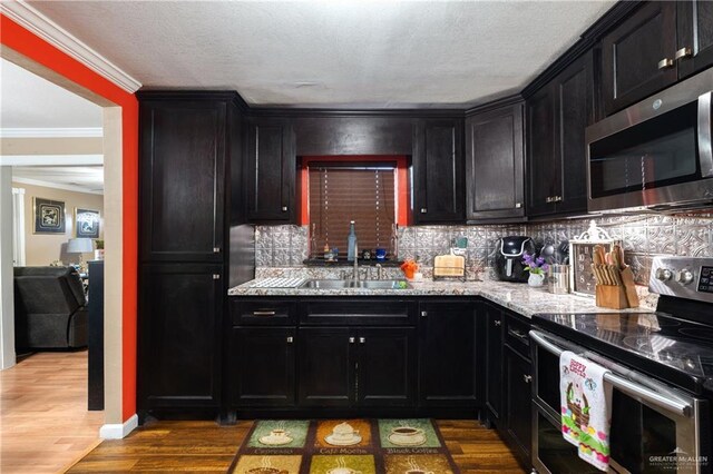 1914 W Barcelona Ave, Harlingen, TX 78550 - kitchen featuring dark cabinets, tasteful backsplash, stainless steel appliances, and a sink