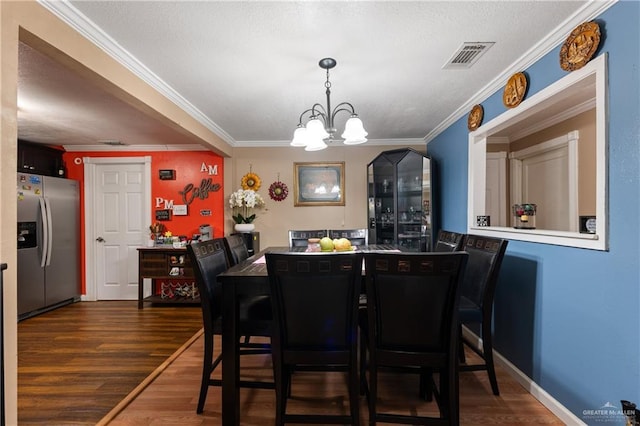 1914 W Barcelona Ave, Harlingen, TX 78550 - dining space featuring dark wood-type flooring, visible vents, a chandelier, and crown molding
