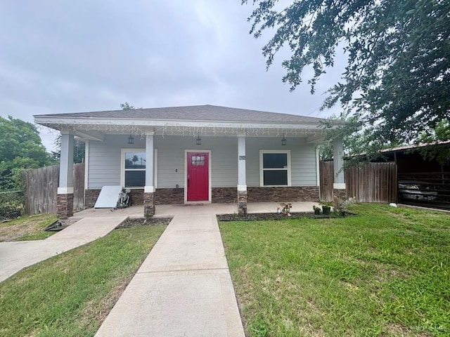 816 Leal St, Mission, TX 78572 - bungalow-style house with fence, covered porch, a front lawn, and stone siding