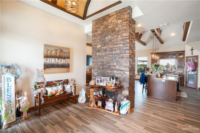 living area featuring baseboards, high vaulted ceiling, wood finished floors, and a multi sided fireplace
