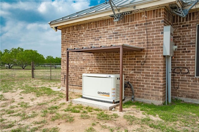 exterior details with a power unit, brick siding, fence, and dirt driveway