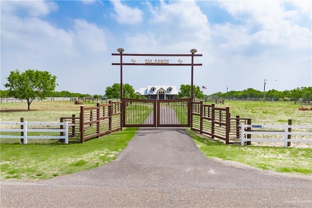 view of gate featuring fence and a rural view