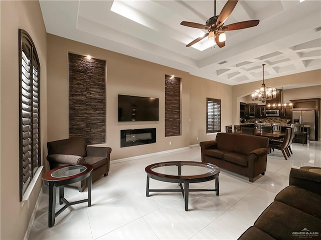 tiled living room featuring coffered ceiling and ceiling fan with notable chandelier