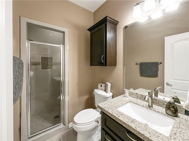 bathroom with vanity, a shower with shower door, and toilet