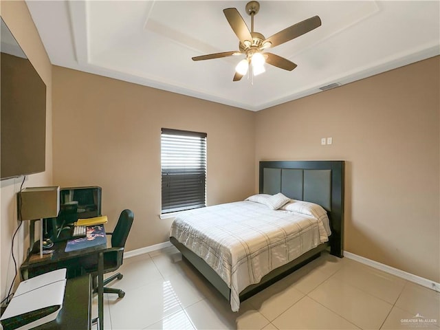 bedroom featuring ceiling fan, a raised ceiling, and light tile patterned floors