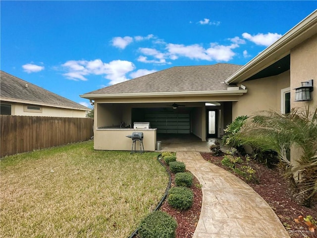 back of property with an outdoor kitchen and a lawn