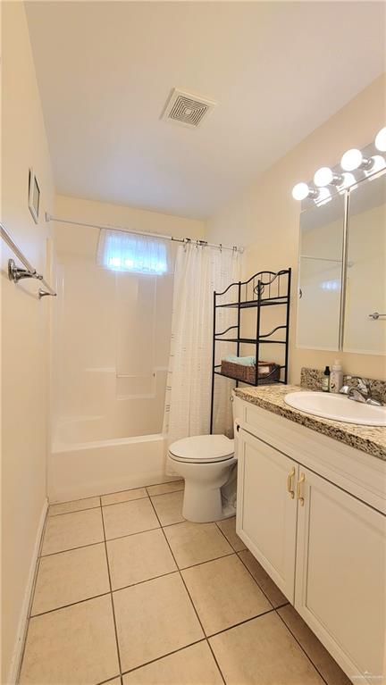 full bathroom with tile patterned floors, shower / tub combo with curtain, vanity, and toilet