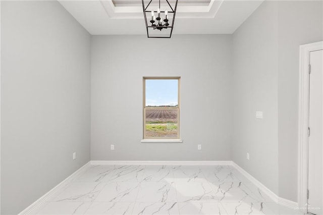 unfurnished room featuring a chandelier