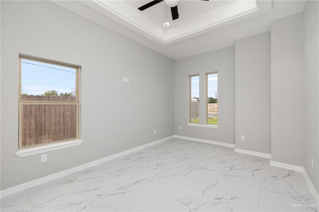 unfurnished room featuring ceiling fan and a raised ceiling