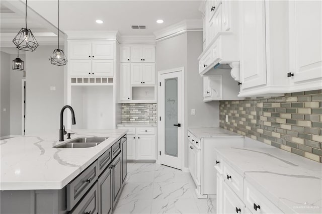 kitchen with sink, white cabinetry, tasteful backsplash, light stone counters, and pendant lighting