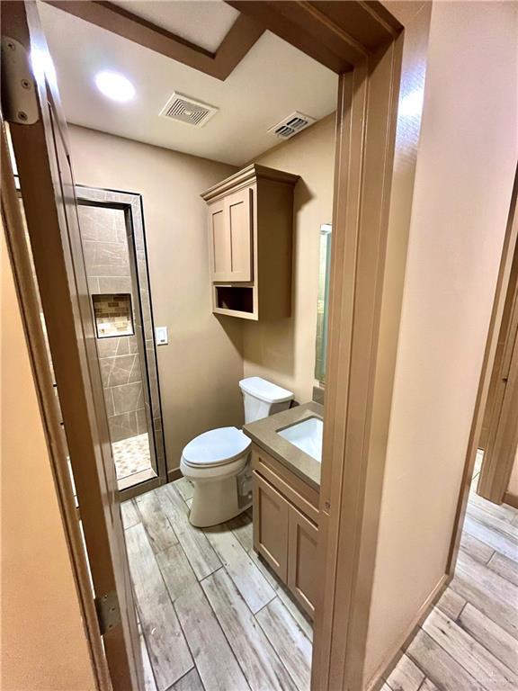 bathroom with vanity, toilet, and a shower with shower door