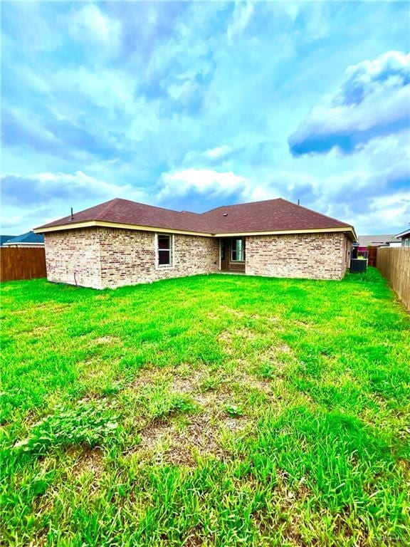 rear view of property with a yard