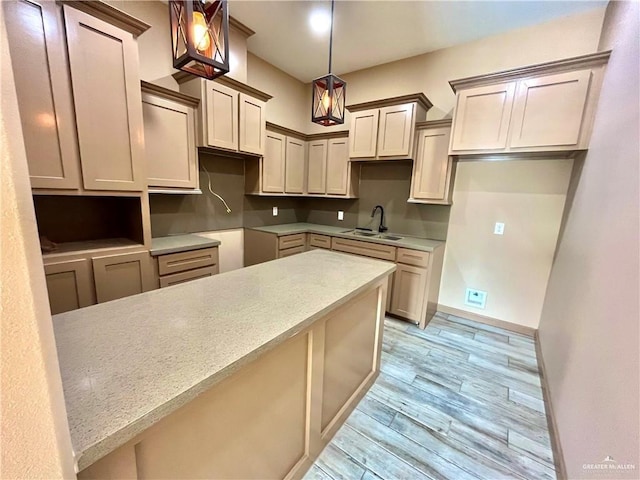 kitchen featuring light hardwood / wood-style floors, sink, and hanging light fixtures