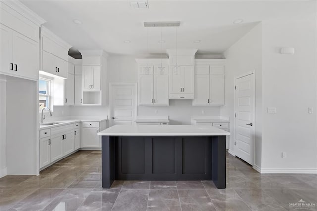 1003 Short Rd, San Juan, TX 78589 - kitchen with a center island, a sink, white cabinets, baseboards, and visible vents