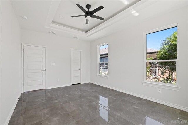 1003 Short Rd, San Juan, TX 78589 - spare room featuring baseboards, a wealth of natural light, a ceiling fan, and a raised ceiling