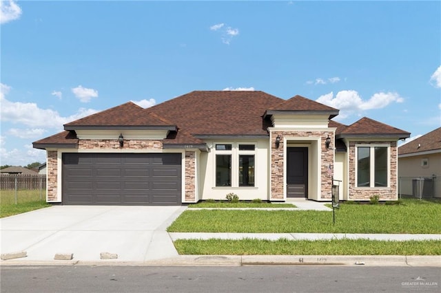 view of front of house featuring a front yard, a garage, and cooling unit