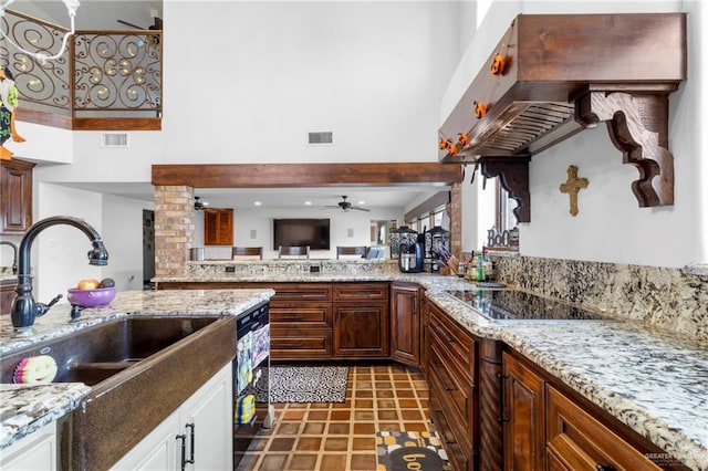 kitchen with ceiling fan, sink, wall chimney range hood, black electric cooktop, and white cabinets