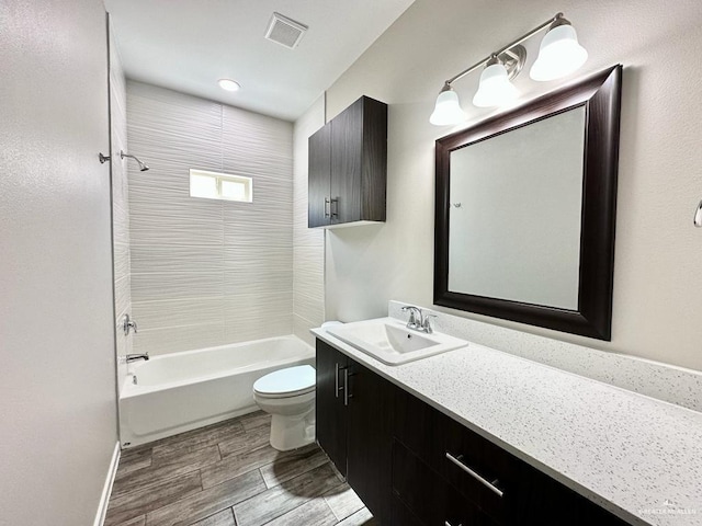 full bathroom with vanity, toilet, and tiled shower / bath