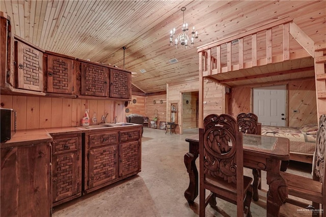 dining area featuring wooden walls, sink, wood ceiling, and an inviting chandelier