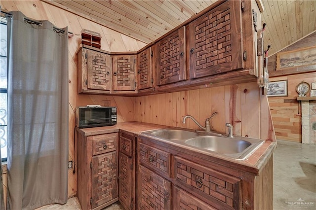 kitchen featuring wooden ceiling, vaulted ceiling, wooden walls, and sink