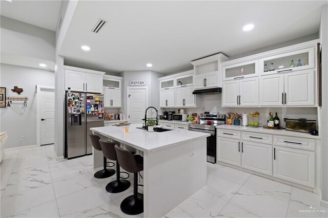 915 Rockford Dr, Alton, TX 78573 - kitchen featuring appliances with stainless steel finishes, light marble finish floors, a sink, a breakfast bar, and recessed lighting