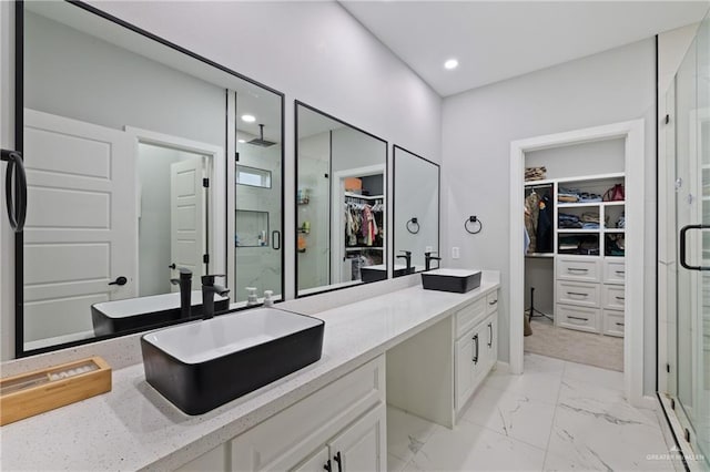 915 Rockford Dr, Alton, TX 78573 - full bathroom with a spacious closet, a shower stall, double vanity, marble look tiles, and recessed lighting