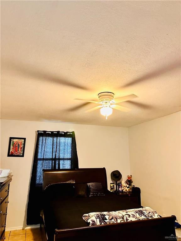 tiled bedroom featuring a textured ceiling and ceiling fan