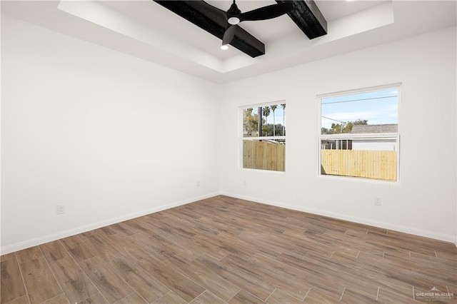 spare room featuring a ceiling fan, wood finished floors, and baseboards