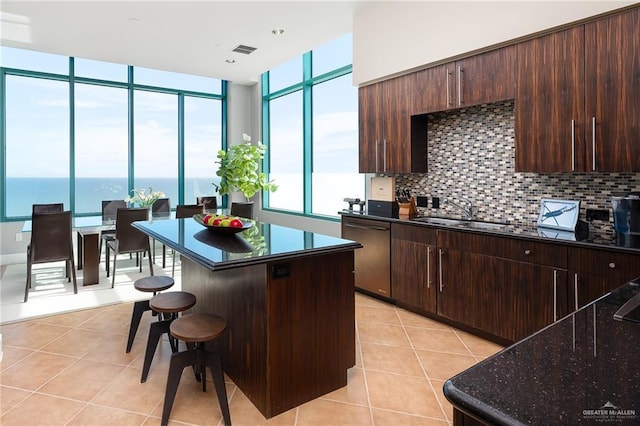 310-A Padre Blvd Unit 3102, South Padre Island, TX 78597 - kitchen featuring stainless steel dishwasher, a sink, light tile patterned flooring, and a kitchen breakfast bar