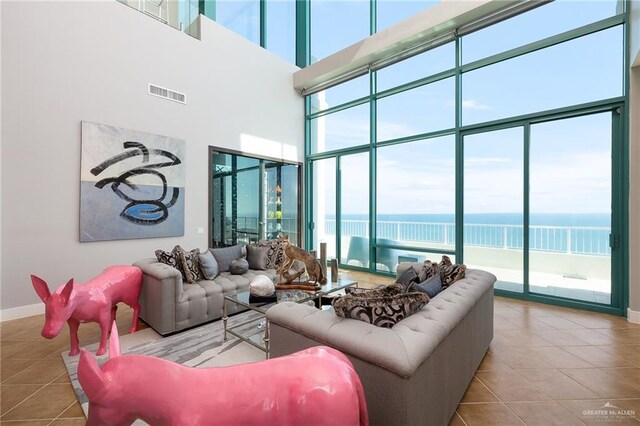 310-A Padre Blvd Unit 3102, South Padre Island, TX 78597 - living area with tile patterned floors, a water view, a towering ceiling, and baseboards