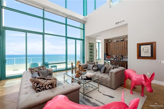 310-A Padre Blvd Unit 3102, South Padre Island, TX 78597 - living area with tile patterned flooring, a towering ceiling, a water view, and baseboards