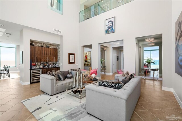 310-A Padre Blvd Unit 3102, South Padre Island, TX 78597 - living room with tile patterned flooring, beverage cooler, baseboards, a dry bar, and a high ceiling